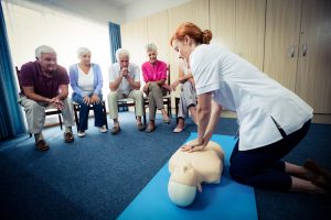 Nurse teaching first aid to a group of seniors in the retirement house