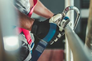 Safety Harness Hook Attaching to Scaffolding by Construction Worker.