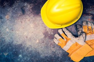 Safety helmet and gloves on a grunge background.