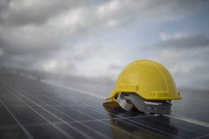 Yellow safety helmet on solar cell panel